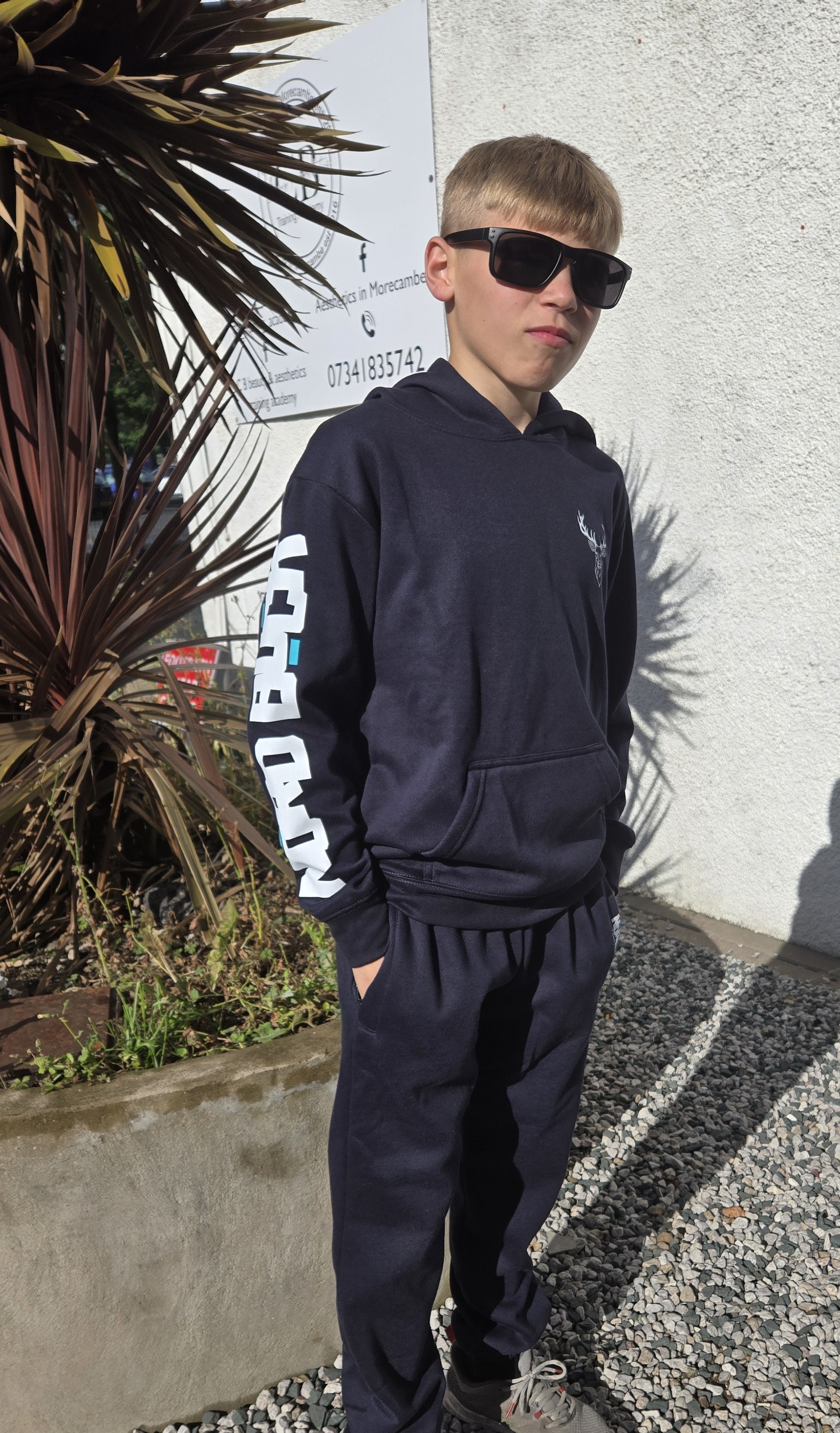 boy wearing blue tracksuit with Nord buck on the arm and stag on the chest logo