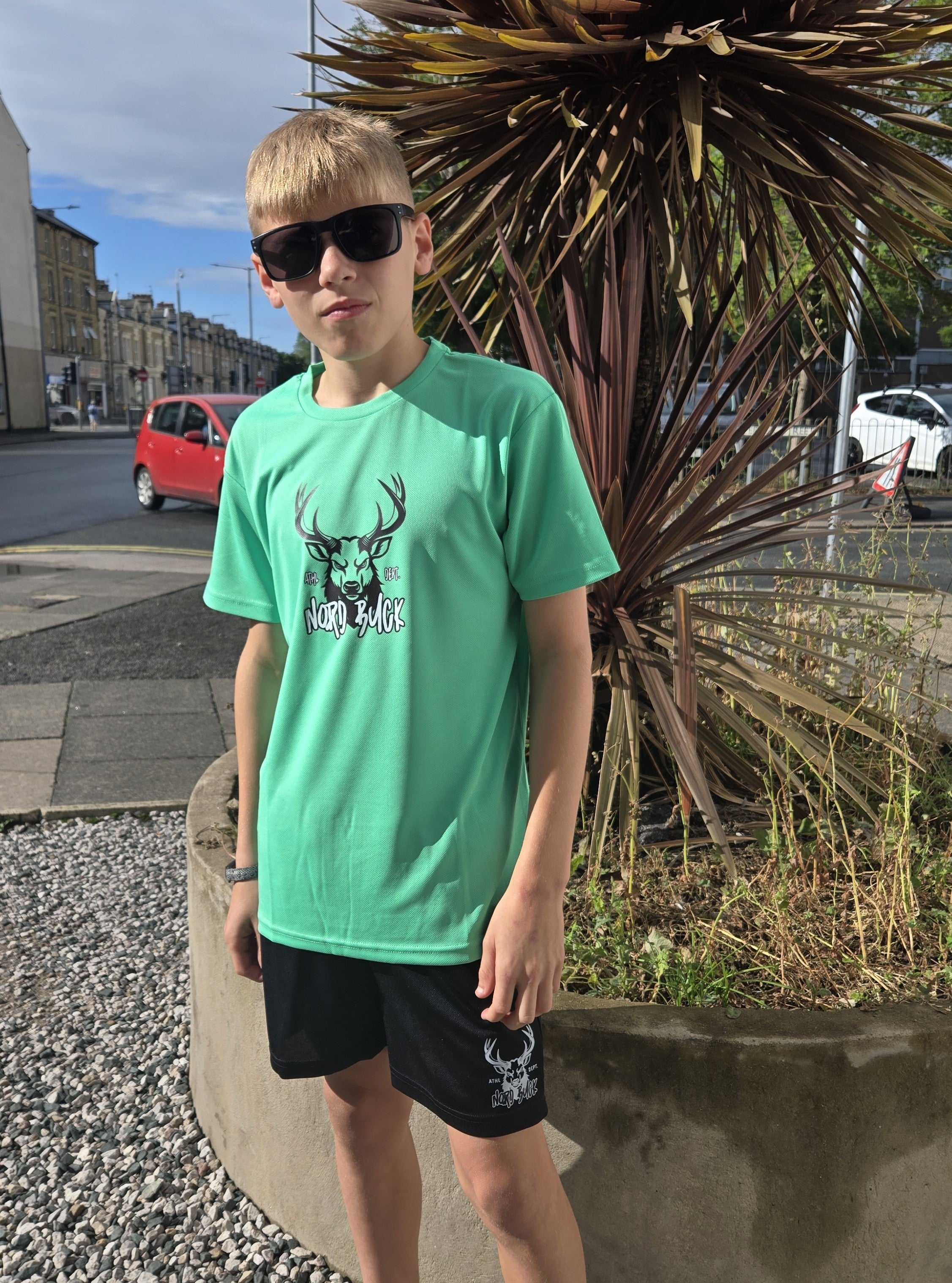 Teenager wearing black shorts with green sports tshirt