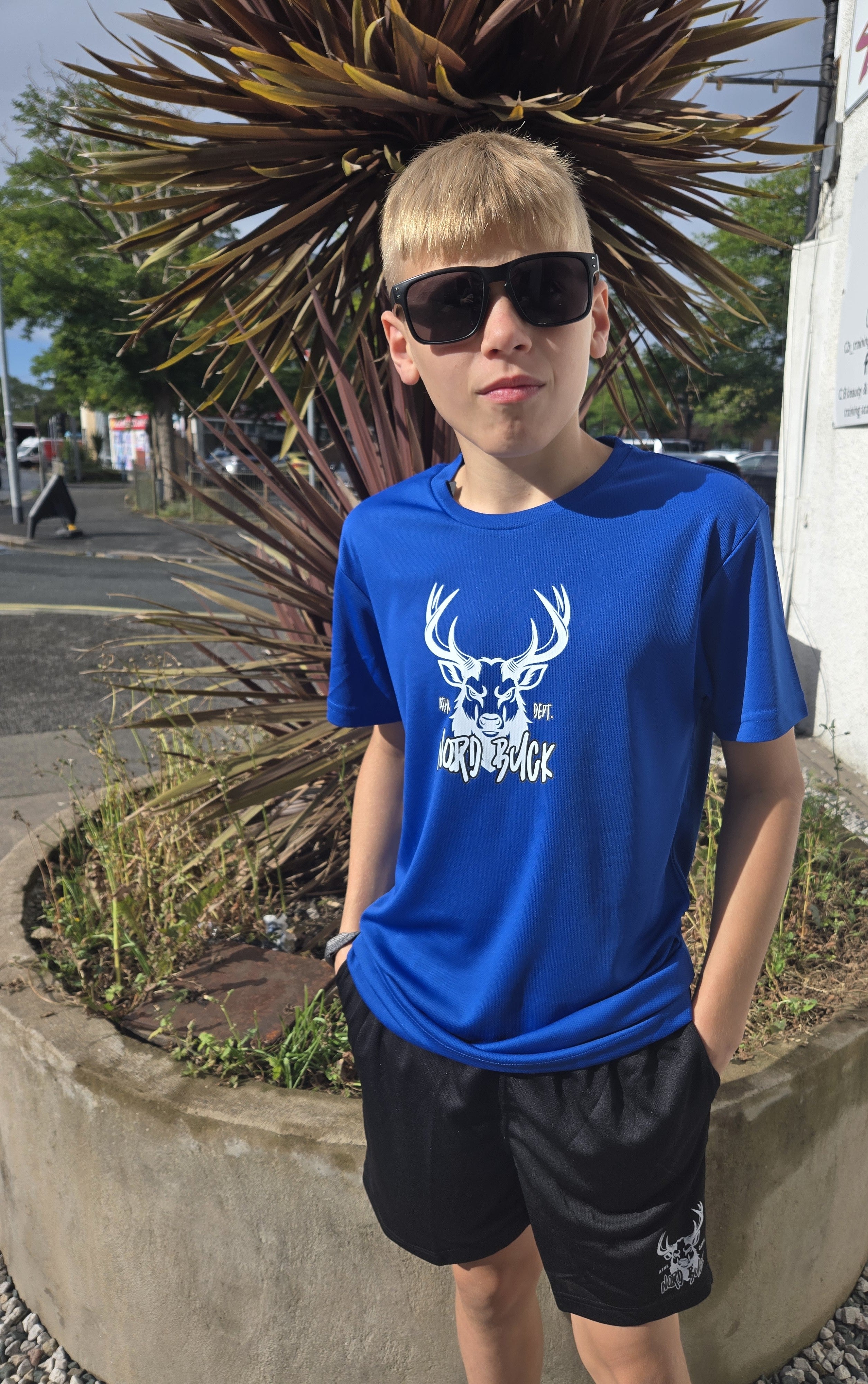 Teenage wearing dark blue sports tshirt outside in the sun