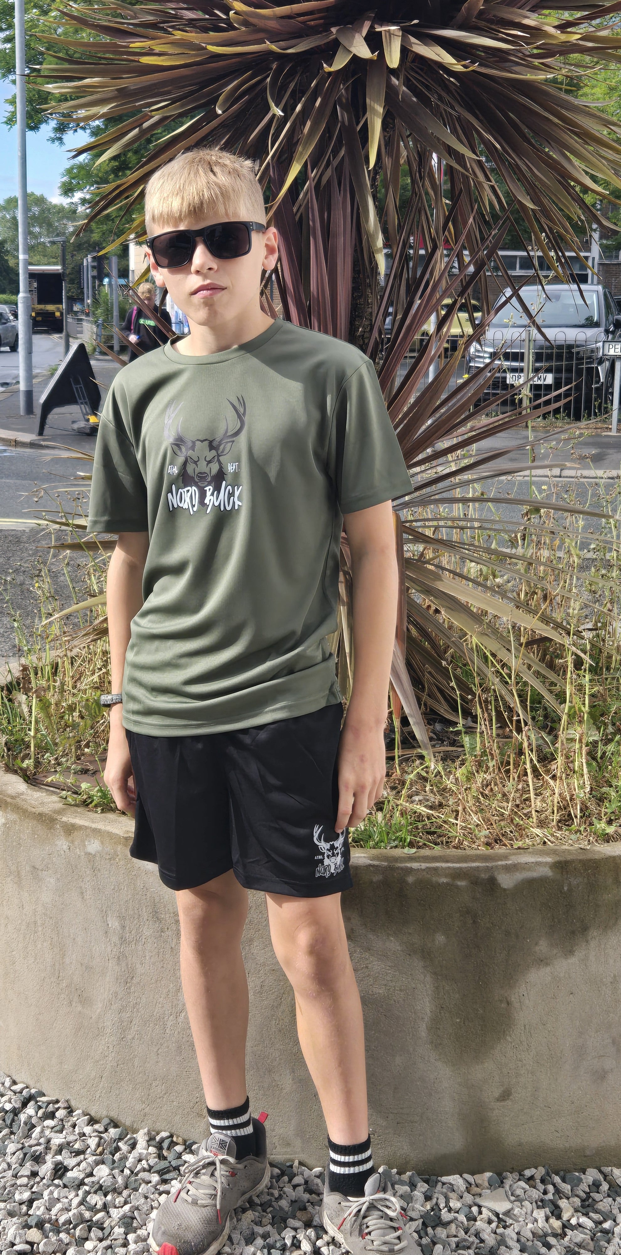 Teenage wearing green sports tshirt outside in the sun