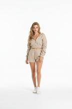 Woman wearing a beige outfit on a white background