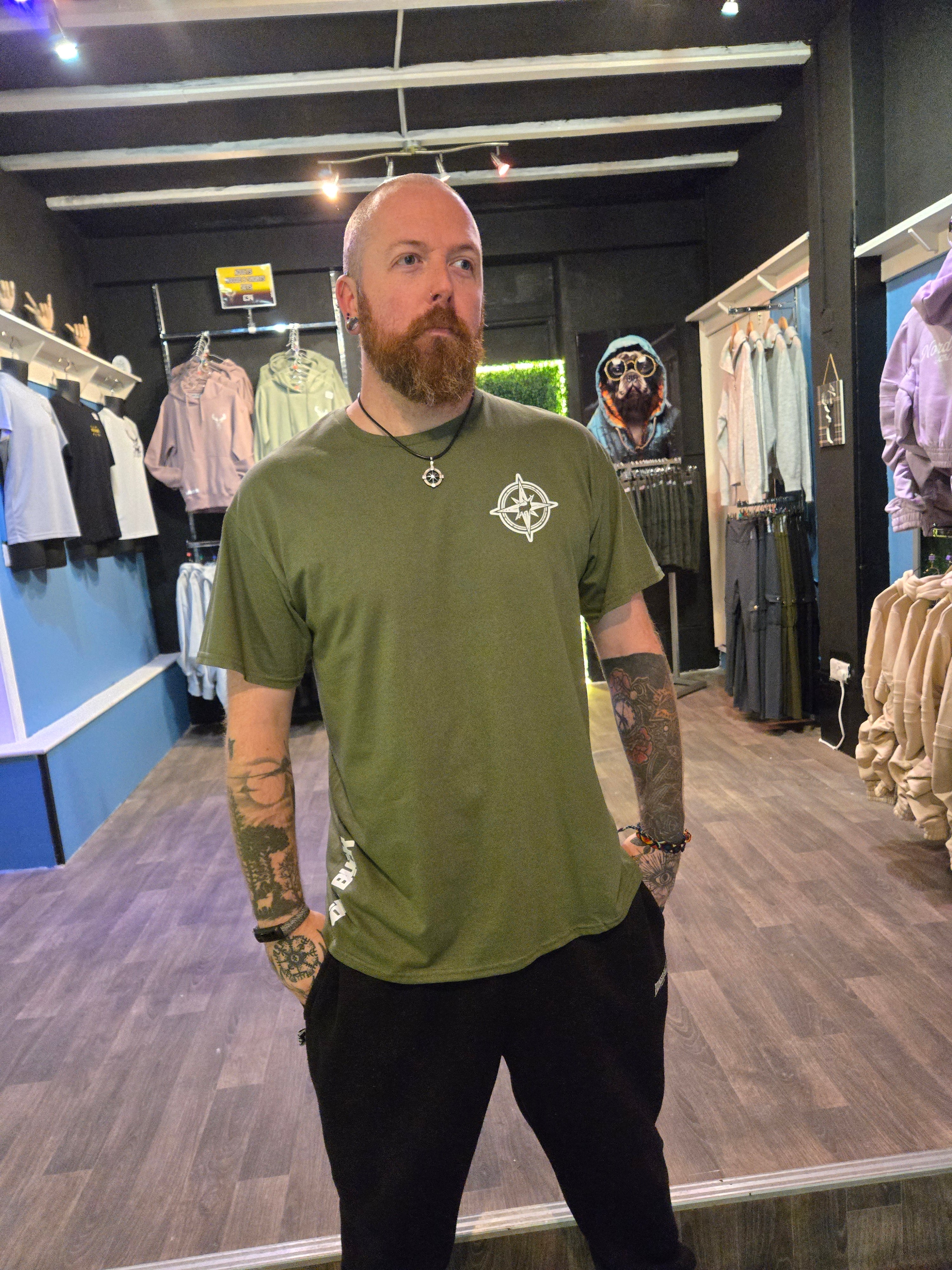 Person wearing a green tshirt with a logo in an indoor setting