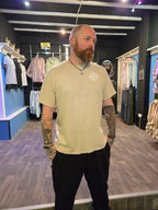 Man wearing a beige shirt with a logo in Nord Buck store.