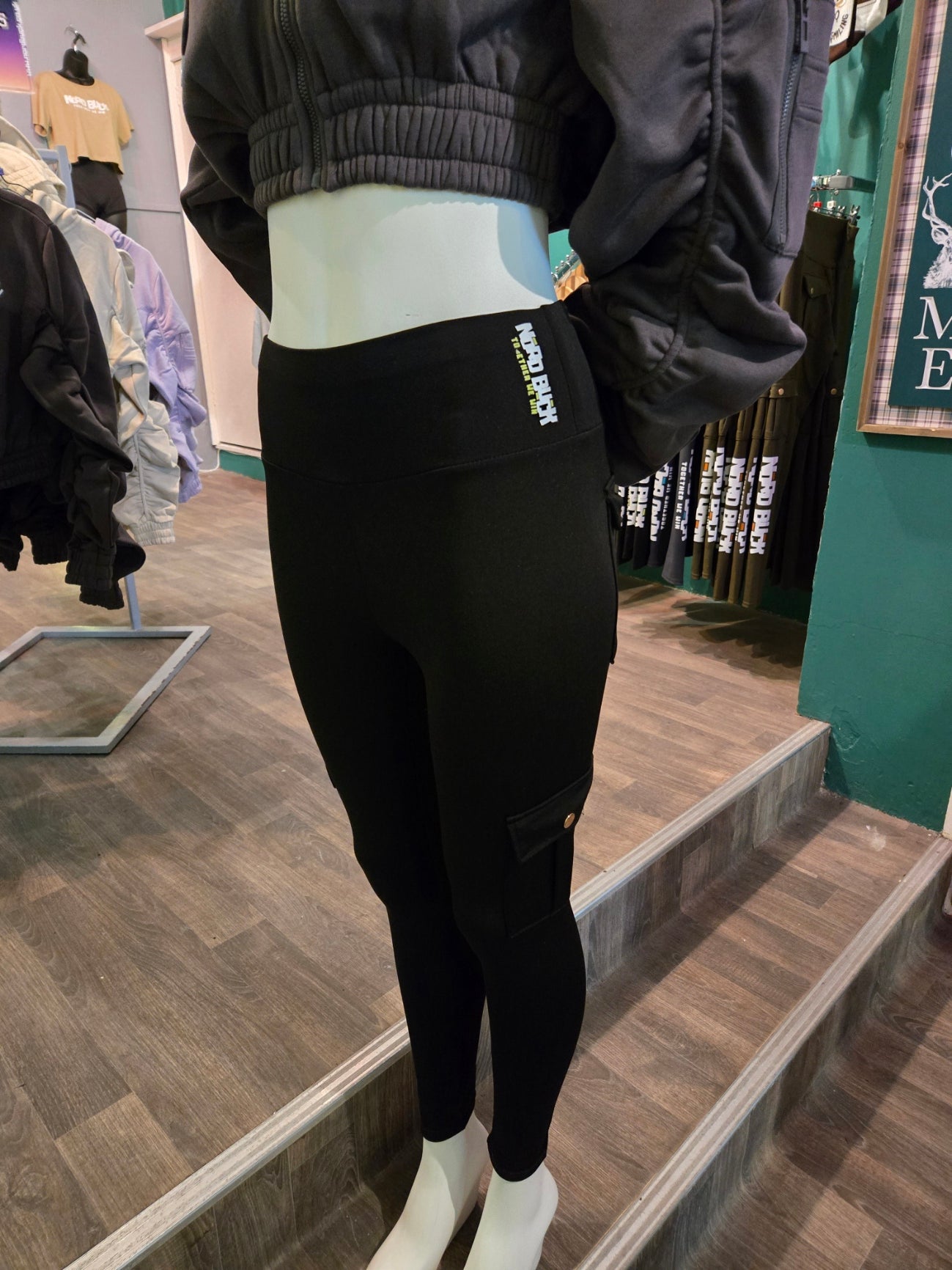Person wearing black leggings with visible branding, standing on a staircase.