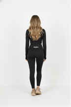 Person wearing a black long-sleeve top and leggings with a logo on a white background