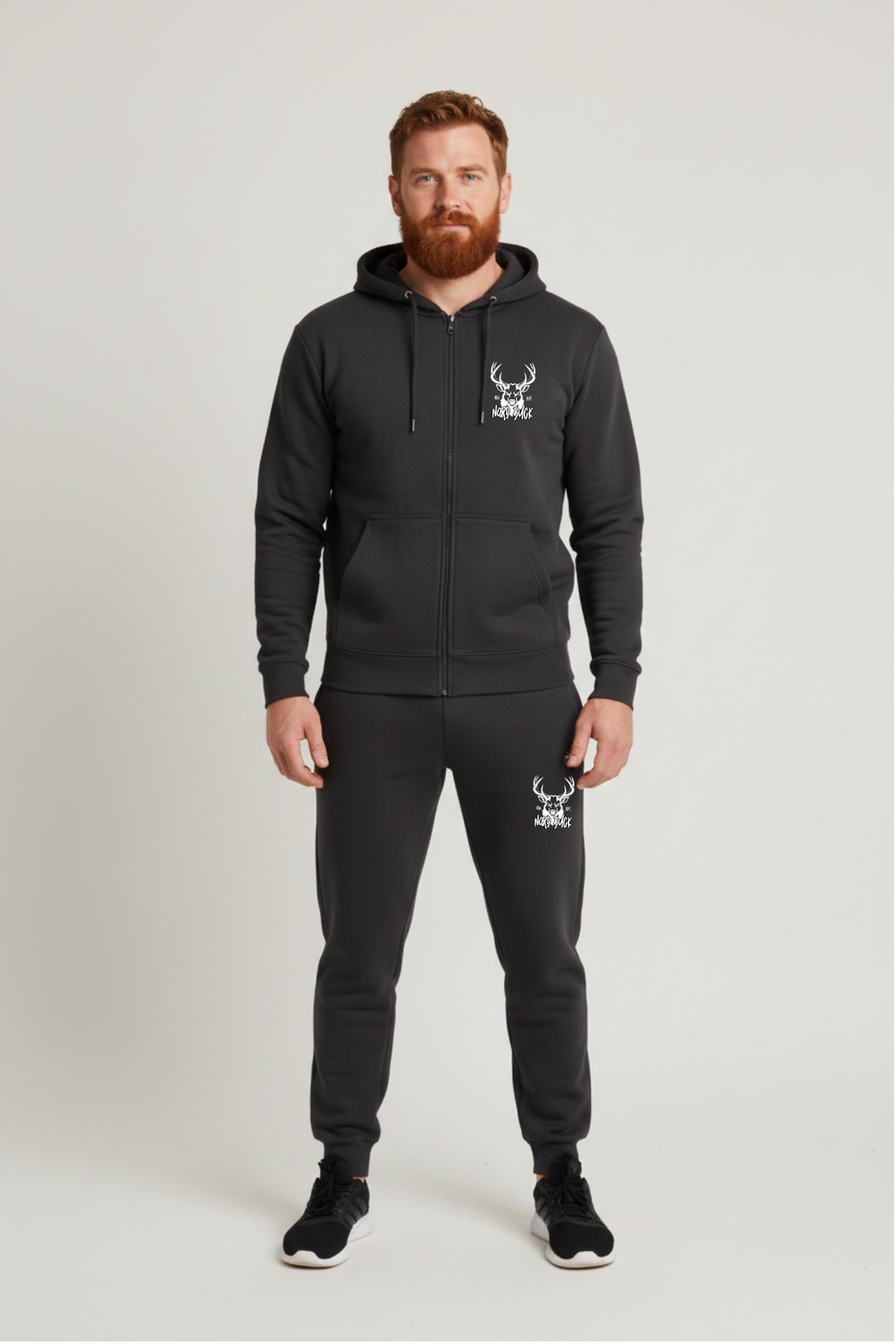 Man wearing a navy hoodie and pants with a logo on a light gray background