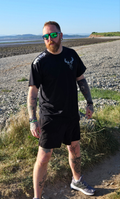 Man wearing black stag tshirt with nord buck logo on a beach