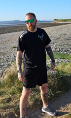 Man wearing black stag tshirt with nord buck logo on a beach