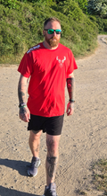 Man wearing red stag tshirt with nord buck logo on a beach