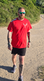 Man wearing red stag tshirt with nord buck logo on a beach