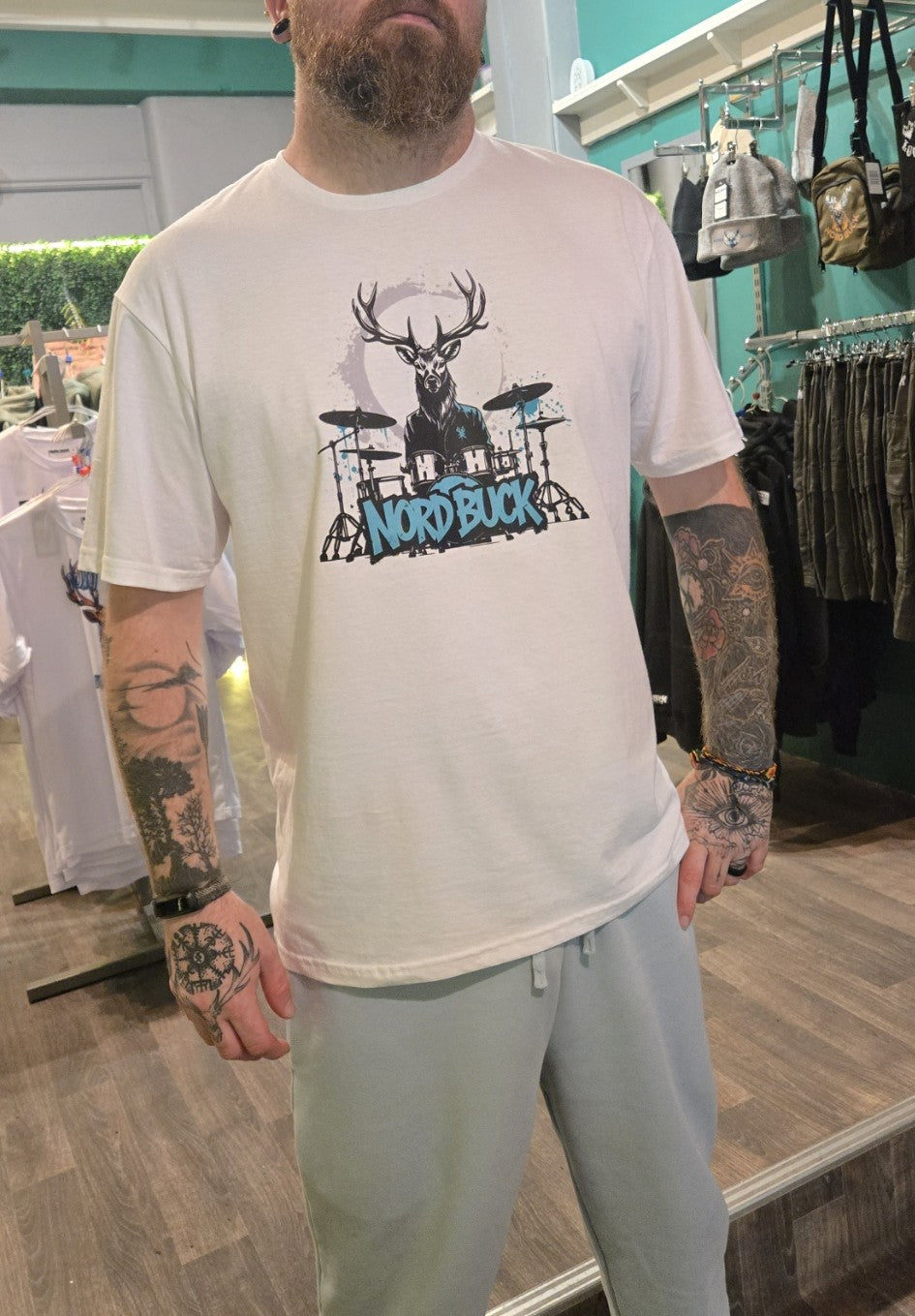 man wearing a t-shirt with a graphic design in a store setting nord buck