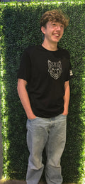 Man wearing black tshirt with silver stag logo on