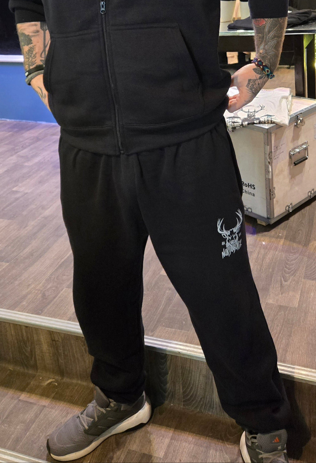 Man wearing a Navy hoodie and pants with a logo in a store setting