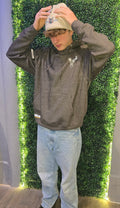 Older teenager wearing charcoal hoodie with beige hat
