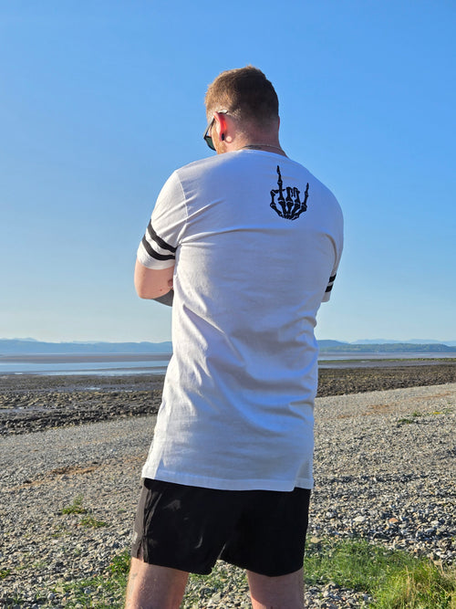Man wearing a long white tshirt with a hand design on the nack
