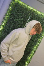 Older teenager wearing grey hoodie from Nord Buck with stag logo on the chest 