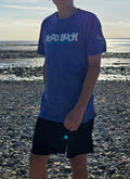 Teenager on the beach wearing a blue tshirt with Nord Buck across the chest 